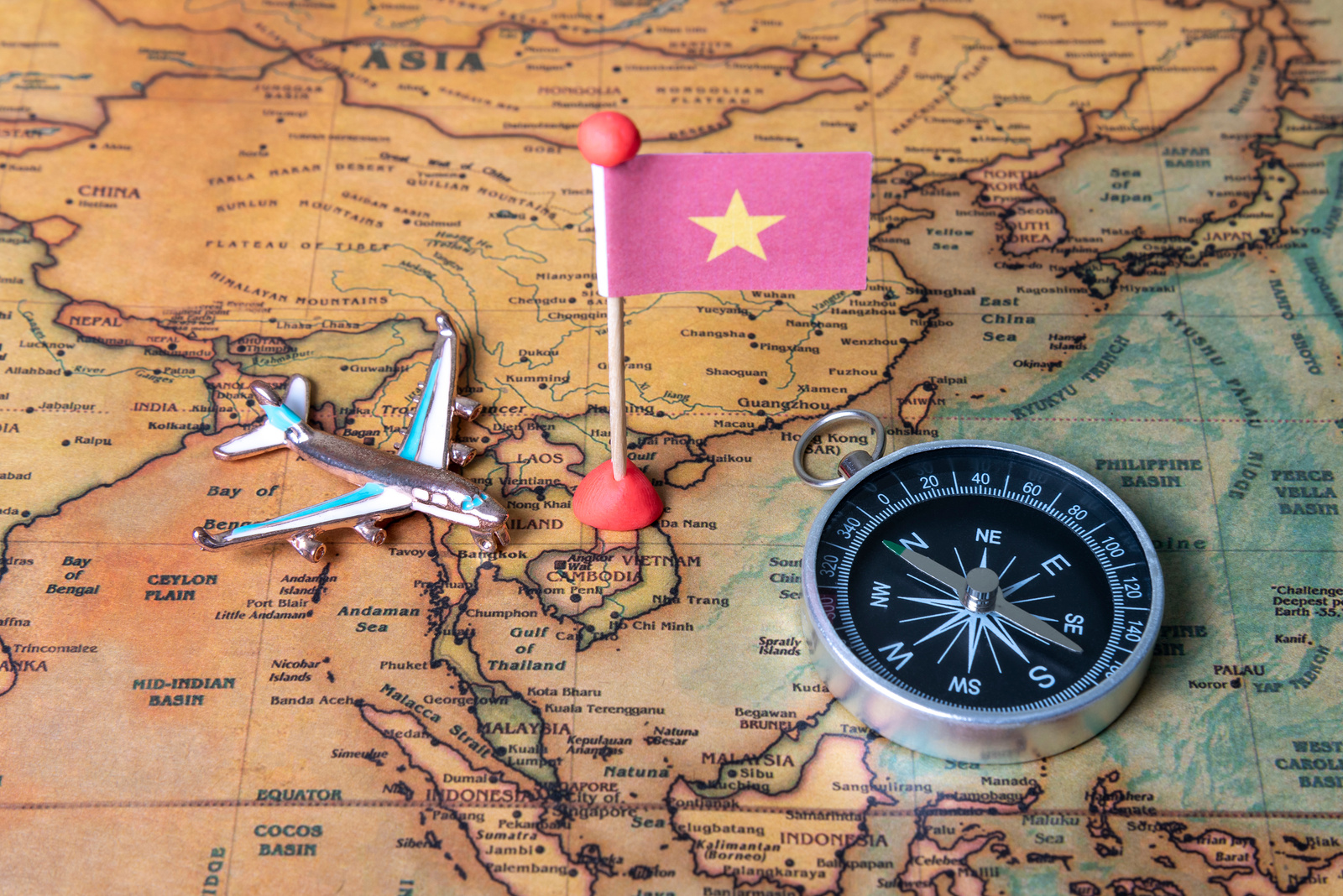 Vietnam flag, compass and airplane on the world map.